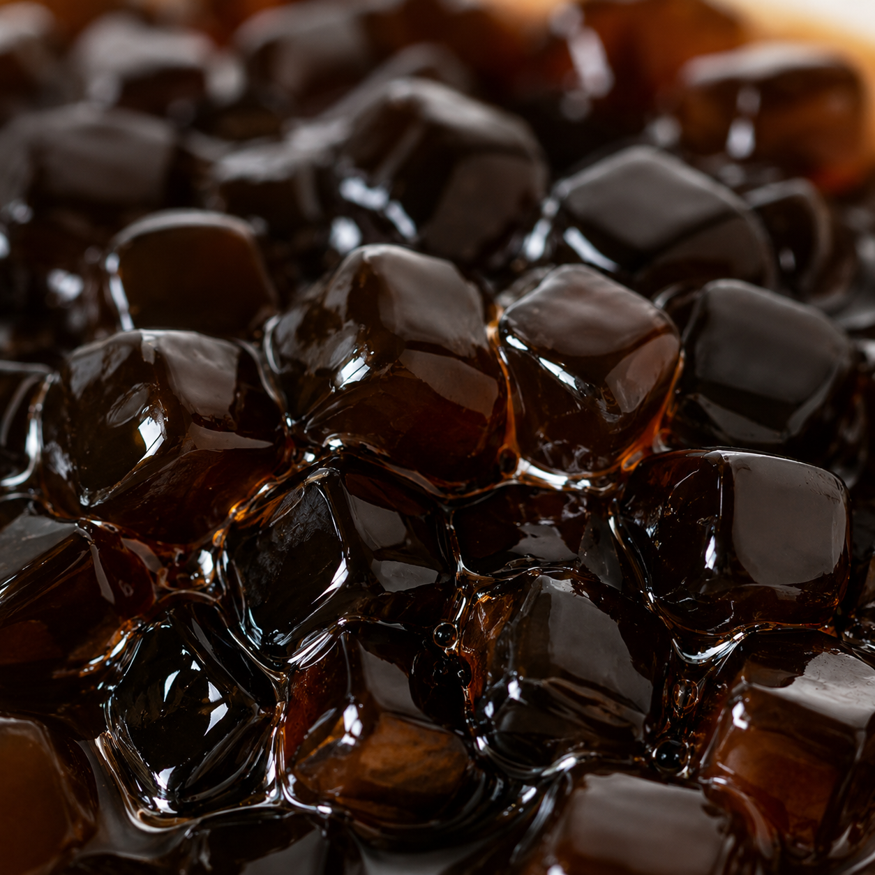 Close-up of Brown Sugar Crystal Boba highlighting glossy translucent chewy pearls coated in rich brown sugar syrup for bubble tea and dessert applications.