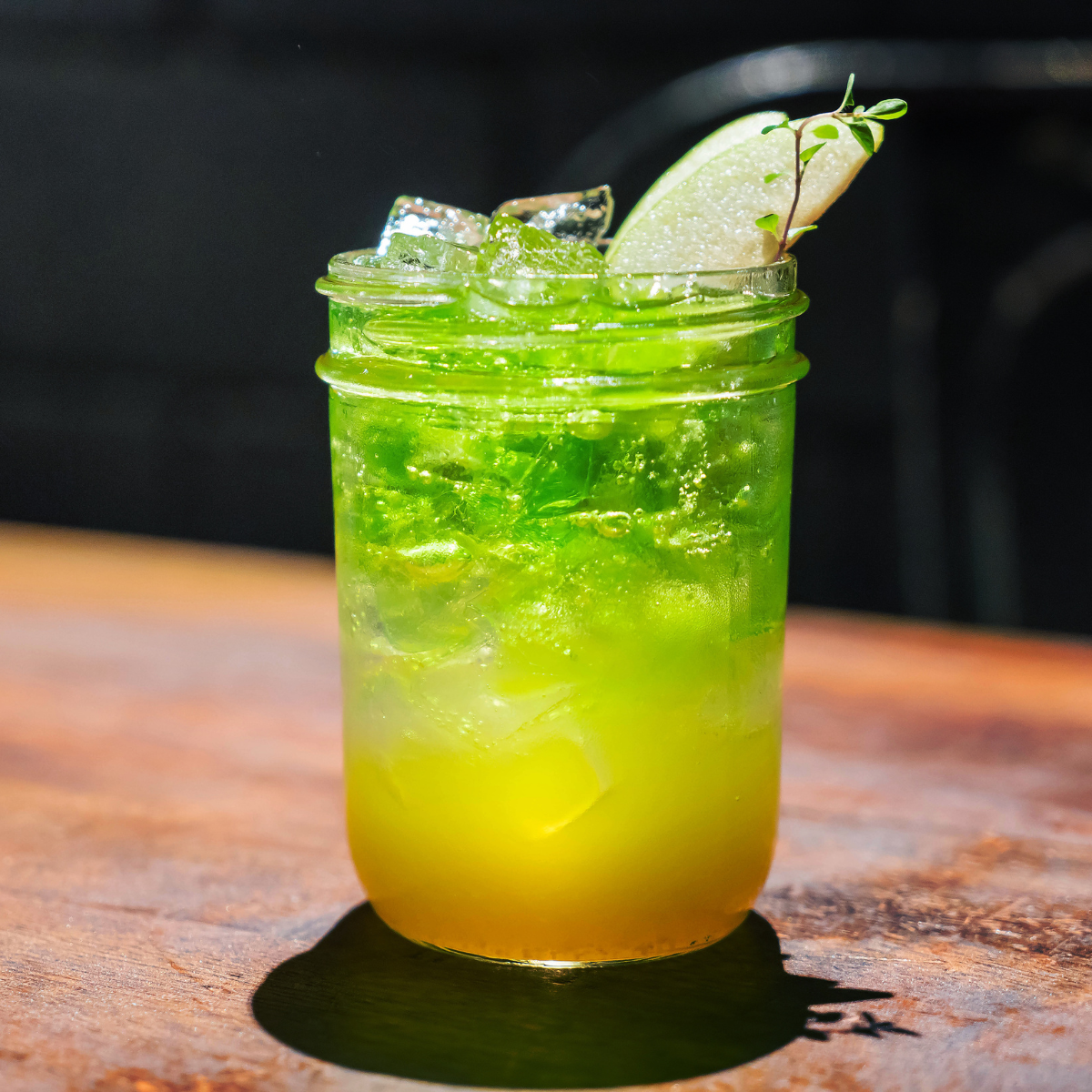 Refreshing green apple soda with ice and a fresh apple slice